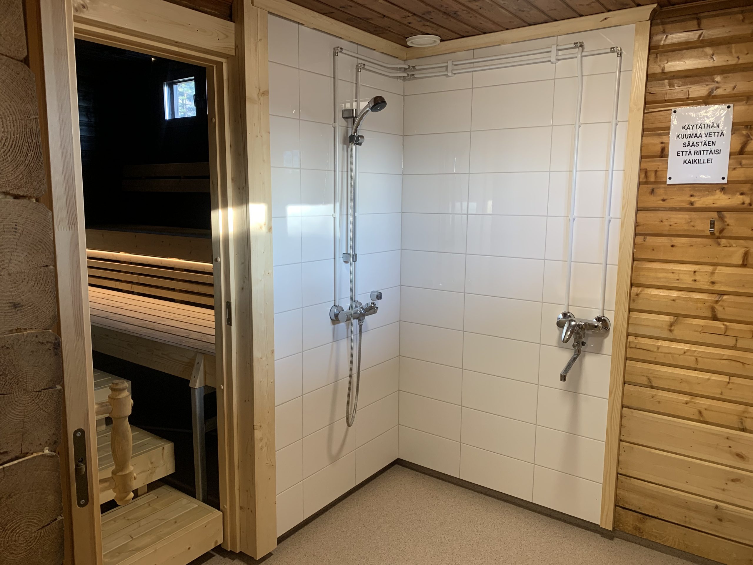 kuvassa kunnan saunan suihku, tilassa valkoinen laattaseinä
